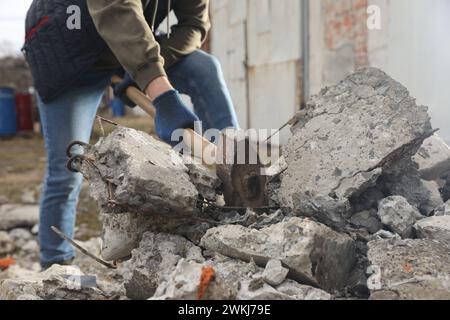 Homme brisant des pierres avec un marteau de forge à l'extérieur, gros plan Banque D'Images