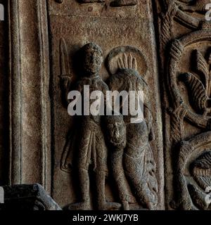 Décapitation de Saint Paul l'Apôtre. Sculpté en relief au milieu des années 1100 dans le style roman lombard à l'entrée de la basilique du monastère de Santa Maria de Ripoll dans la province de Gérone, Catalogne, Espagne. Le bourreau tient la tête de Saint Paul dans sa main gauche et l'épée dans sa main droite. Le corps sans tête de Saint Paul, le sang jaillit du cou, est à droite du bourreau. Selon la tradition, Saint Paul l'Apôtre (c. 4 EC à c. 64 EC) a été décapité à Rome et est mort en martyr pour sa foi chrétienne. Banque D'Images