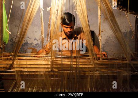 Un artisan tisserand de soie travaillant dans un atelier textile à Varanasi, Uttar Pradesh, Inde. Banque D'Images