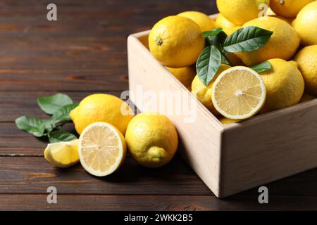 Citrons frais dans la caisse sur la table en bois Banque D'Images