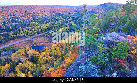 Forêt d'automne aérienne avec route panoramique et lac réfléchissant, Michigan Banque D'Images