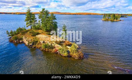 Île d'automne aérienne dans le lac avec rivage forestier Banque D'Images