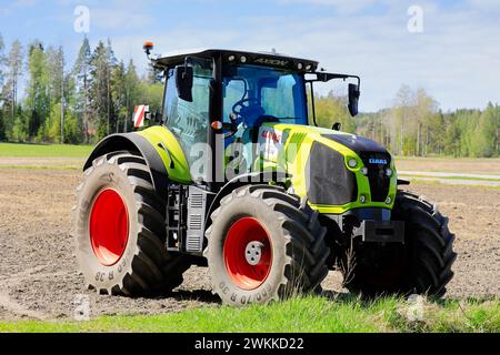 Tracteur CLAAS Axion 850 dans les champs par une journée ensoleillée de printemps. Salo, Finlande. 20 mai 2023. Banque D'Images