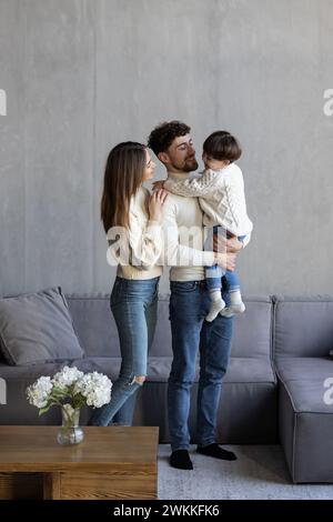 Portrait de tête photographié couple hispanique heureux et fils d'âge préscolaire assis sur le canapé à la maison souriant regardant la caméra. Prêt bancaire, couverture d'assurance médicale pour les jeunes Banque D'Images