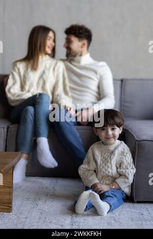 Portrait de tête photographié couple hispanique heureux et fils d'âge préscolaire assis sur le canapé à la maison souriant regardant la caméra. Prêt bancaire, couverture d'assurance médicale pour les jeunes Banque D'Images