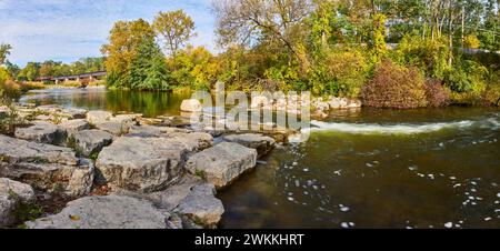 Rivière sereine avec pont couvert et panorama du feuillage d'automne Banque D'Images