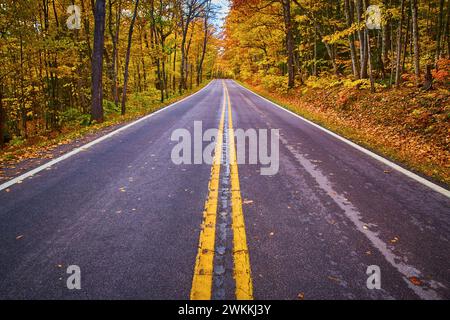 Splendeur d'automne sur la route sereine Keweenaw - asphalte humide et feuillage d'automne Banque D'Images