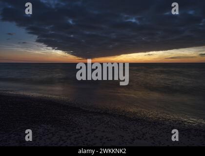 Nuages noctilucents et formation de nuages sombres au-dessus de l'horizon à la plage danoise au coucher du soleil crépuscule Banque D'Images