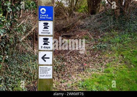 Panneau d'amarrage des visiteurs près du canal & River Trust indiquant une limite de 2 jours, contre le feuillage naturel. Banque D'Images