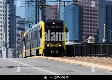 Los Angeles, Californie, États-Unis - 11 février 2024 : métro E Line train de banlieue traversant le pont de la 1ère rue avec le centre-ville de Los Angeles. Banque D'Images