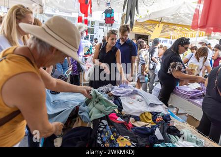 Shopping dans les marchés aux puces qui bordent les rues du quartier Navigli de Milan où les étals de vêtements et d'accessoires sont bondés de locaux. Banque D'Images