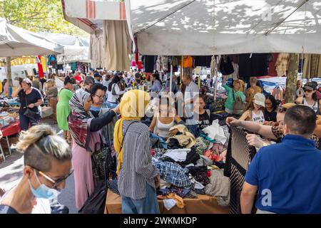 Shopping dans les marchés aux puces qui bordent les rues du quartier Navigli de Milan où les étals de vêtements et d'accessoires sont bondés de locaux. Banque D'Images