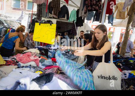 Shopping dans les marchés aux puces qui bordent les rues du quartier Navigli de Milan où les étals de vêtements et d'accessoires sont bondés de locaux. Banque D'Images