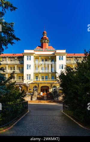 Polanica-Zdroj, Pologne - 21 octobre 2023 : façade de beau et grand bâtiment du sanatorium Wielka Pieniawa au centre de la ville à côté de la promenade et b Banque D'Images