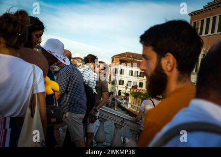 Les gens viennent aux ponts sur Venise pour être vus et admirer le coucher du soleil. Un jeune couple amoureux sur un pont sur le Grand canal. Banque D'Images