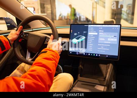 Gros plan mains masculines sur le volant, Tesla modèle de voiture électrique 3 intérieur, cockpit technologies modernes EV fabrication de voitures, tel que pilote automatique, éco-frite Banque D'Images