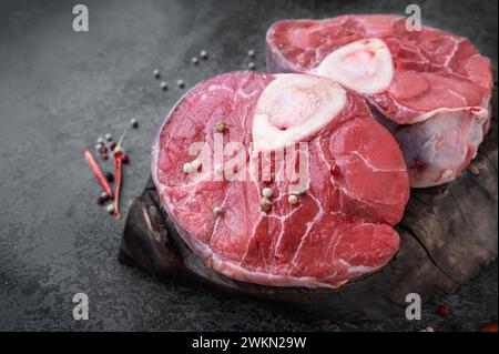 ossobuco. Steak d'ossobuco de bœuf cru, ossobuco italien avec épices de cuisson. Fond noir. Vue de dessus. Banque D'Images