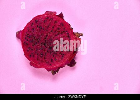 Ensemble de fruits de dragon rouge avec service appétissant isolé sur fond rose. Vue de dessus, main Banque D'Images