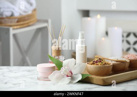 Belle composition avec différents produits de spa et fleur d'orchidée sur table en marbre blanc à l'intérieur. Espace pour le texte Banque D'Images