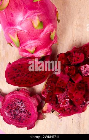 Ensemble de fruits de dragon rouge avec service appétissant isolé sur fond rose. Vue de dessus, main Banque D'Images