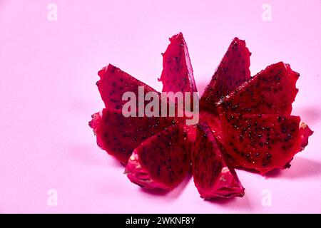 Ensemble de fruits de dragon rouge avec service appétissant isolé sur fond rose. Vue de dessus, main Banque D'Images