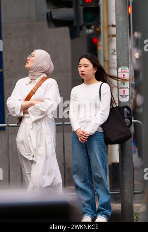 Femmes ethniques qui comprennent des races mixtes avec la diversité culturelle attendant à l'arrêt de tram pour le tramway dans la ville de Melbourne, en Australie. Banque D'Images