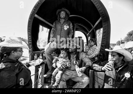 Prairie View, Texas, États-Unis. 20 février 2024. Les Black Cowboys et les Cowgirls prennent une pause déjeuner dans leur wagon couvert dans le comté de Waller, Texas, lors de la 67e randonnée annuelle de la Prairie View Trail Riders Association sur le sentier Prairie View Trail Riders Association lors de leur périple de 100 km au départ de Hempstead, TX à Houston pour le Houston Livestock Show and Rodeo annuel à Houston TX du 27 février au 17 mars. La PVTRA a été fondée en 1957 et leur but est de promouvoir l'intérêt agricole pour les jeunes Américains et de perpétuer ces principes et méthodes qui sont devenus les idéaux et la traditio Banque D'Images