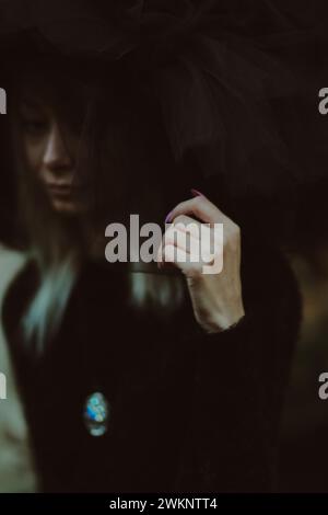 Image en gros plan avec le visage d'une femme partiellement obscurci par le tissu de tulle, créant une sensation énigmatique Banque D'Images