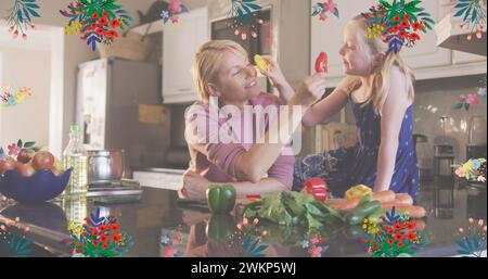 Image de fleurs sur une mère caucasienne heureuse et sa fille cuisiner à la maison Banque D'Images