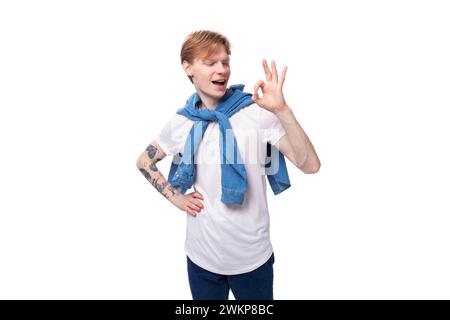 jeune mec caucasien mignon avec les cheveux rouges courts avec un tatouage sur ses bras en gestation active Banque D'Images