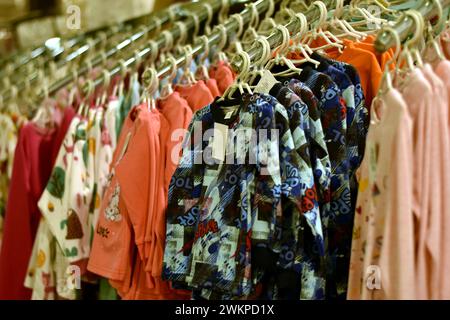 Vitrine dans un magasin avec des vêtements pour enfants et des chemisiers. Banque D'Images