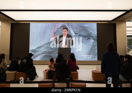 SHANGHAI, CHINE - 22 FÉVRIER 2024 - les clients s'inscrivent et regardent le lancement du téléphone à écran pliant vertical Pocket2 de Huawei au drapeau Huawei Banque D'Images