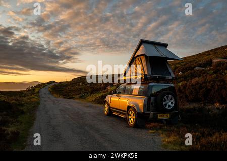 Un Landrover Defender 110 avec une tente de toit en Écosse Banque D'Images