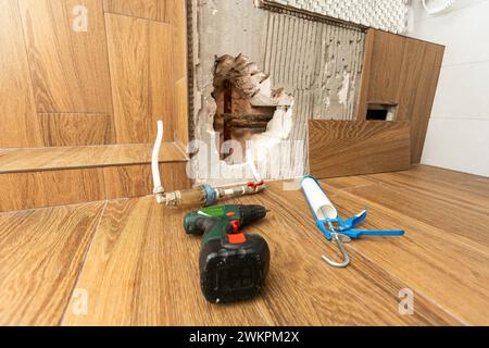 Trou dans le mur intérieur et tuyaux de chauffage Banque D'Images