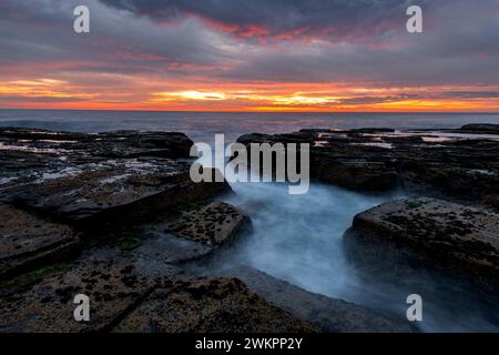 Lever de soleil sur les rochers à Narrabeen sur les plages du nord de Sydney. Banque D'Images