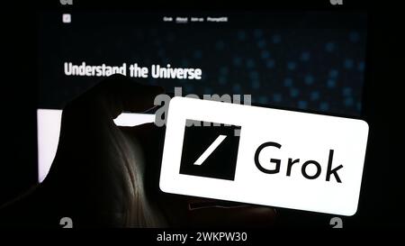 Personne tenant un téléphone portable avec le logo du chatbot d'intelligence artificielle générative Grok (X.ai) devant la page Web. Concentrez-vous sur l'affichage du téléphone. Banque D'Images