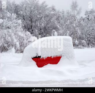 Une Smart rouge, une petite voiture, garée et complètement couverte dans la neige, hiver, Munich, Bavière, Allemagne Banque D'Images