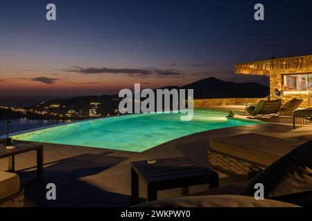 IOS, Grèce - 17 septembre 2023 : vue sur une piscine dans un bar lounge et un coucher de soleil magique à iOS Grèce Banque D'Images