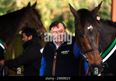 Entraîneur Nicky Henderson avec le cheval Constitution Hill (à droite) et Jonbon en arrière-plan (à gauche) lors d'une visite de la cour de Nicky Henderson à Seven Barrows à Lambourn, Berkshire. Date de la photo : jeudi 22 février 2024. Banque D'Images