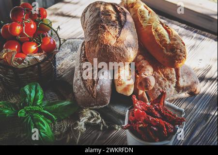 Assortiment de divers délicieux pains fraîchement cuits sur un fond en bois blanc. Ciabatta, grissini, pâtisseries, baguette de différentes variétés avec su Banque D'Images