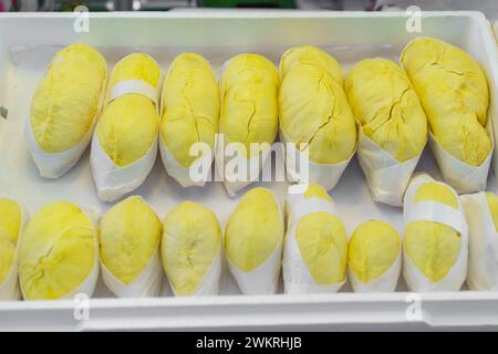 Fruit de durian fraîchement pelé, connu sous le nom de «roi des fruits», soigneusement emballé dans un film plastique et exposé à la vente Banque D'Images