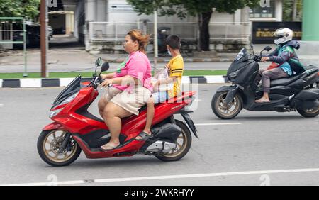 SAMUT PRAKAN, THAÏLANDE, octobre 11 2023, Une femme roule avec un garçon sur une moto. Banque D'Images