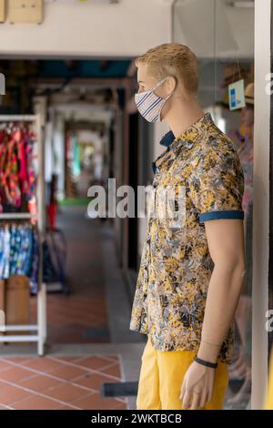 Mannequin homme avec un masque exposé à l'extérieur d'un magasin Banque D'Images