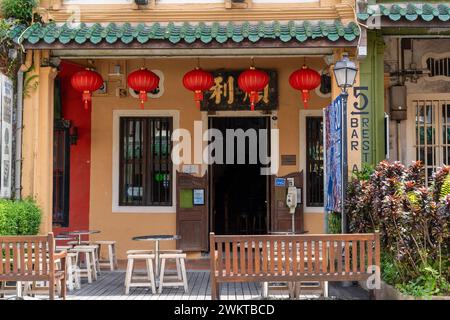 Bancs en bois devant un bâtiment avec des lanternes chinoises suspendues au-dessus Banque D'Images