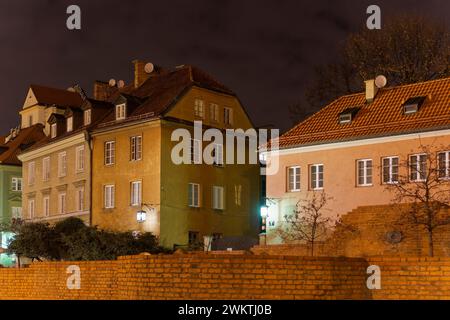 Vue nocturne à angle bas des maisons traditionnelles de faible hauteur en tuiles autour des fortifications défensives dans la vieille ville de Varsovie, en Pologne. Banque D'Images