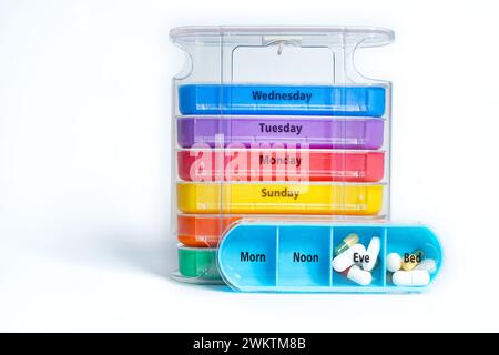 Un organisateur de pilules empilable hebdomadaire quatre fois par jour. La boîte de comprimés a un plateau pour chaque jour de la semaine avec quatre compartiments séparés marqués. Banque D'Images