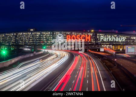 Autobahn A8 AM Flughafen Stuttgart mit Bosch-Parkhaus. Die 440 mètre lange Konstruktion bietet 4200 Fahrzeugen Platz. Bosch Hat die Namensrechte, der stilisierte Zündanker misst 12 Meter im Durchmesser. Damit ist es eine der größten Leuchtreklamen der Welt. // 04.05.2024 : Stuttgart, Bade-Württemberg, Allemagne. *** Autoroute A8 à l'aéroport de Stuttgart avec parking Bosch à plusieurs étages la structure de 440 mètres de long offre un espace pour 4 200 véhicules Bosch a les droits de dénomination, l'ancre d'allumage stylisée mesure 12 mètres de diamètre, ce qui en fait l'un des plus grands panneaux lumineux du monde Banque D'Images