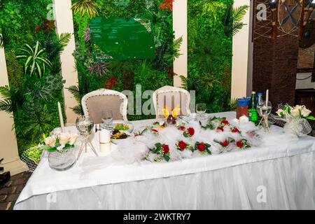 Une table de mariage festive et joliment décorée. Décoré avec des fleurs.diverses bouteilles de boissons, de beaux plats, des salades et des rouleaux de viande tranchés.ve Banque D'Images