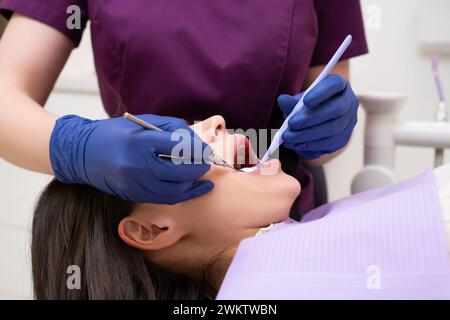 Un patient fait examiner ses dents par le dentiste au cabinet dentaire Banque D'Images