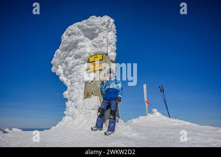 Un petit garçon a grimpé au sommet de Baranec dans les Tatras Zapadny par beau temps d'hiver. Banque D'Images